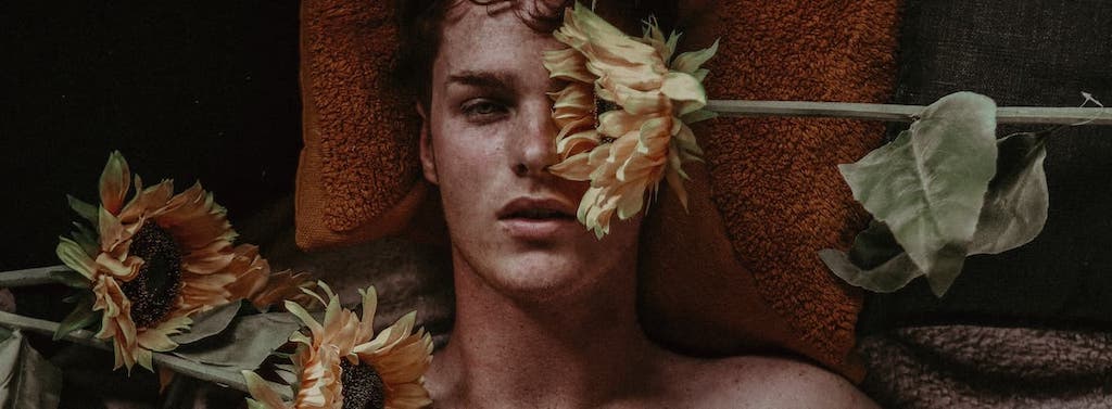 young guy reclining in a trance with flowers
