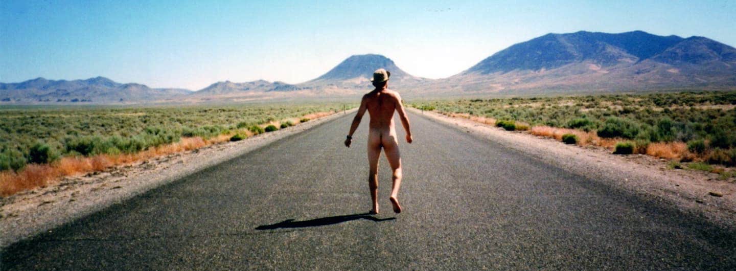 rear shot of naked guy on a desert highway