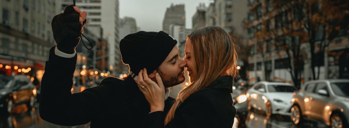 couple kissing beneath umbrella