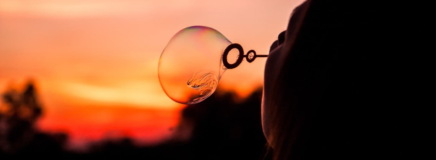 blowing a bubble at sunset